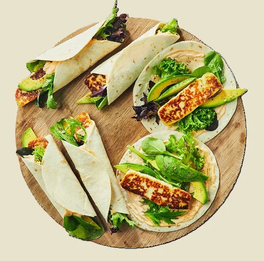 Fresh halloumi and avocado wraps on a serving board